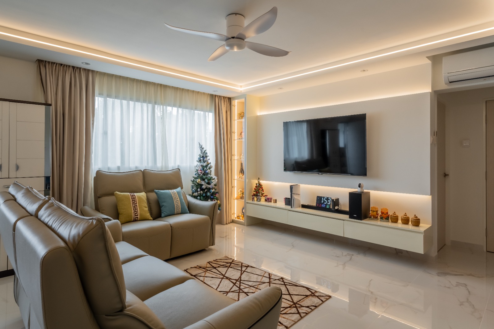 Modern 4-room HDB living room in Woodlands with warm lighting, built-in TV feature wall and neutral interiors